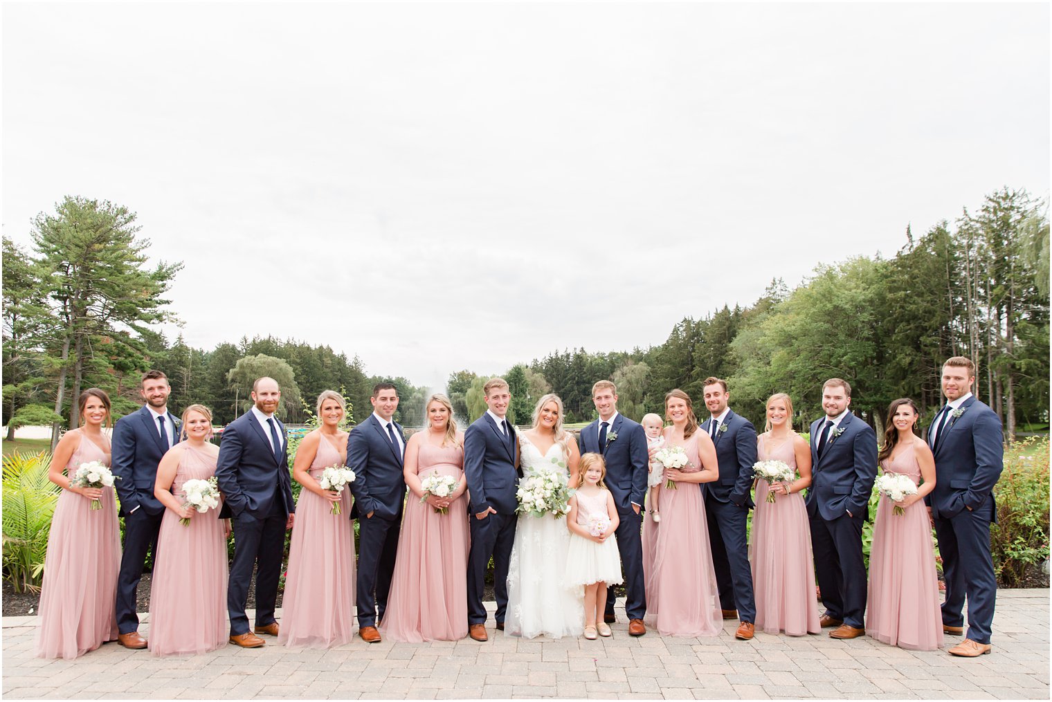 newlyweds pose with wedding party in pink and navy