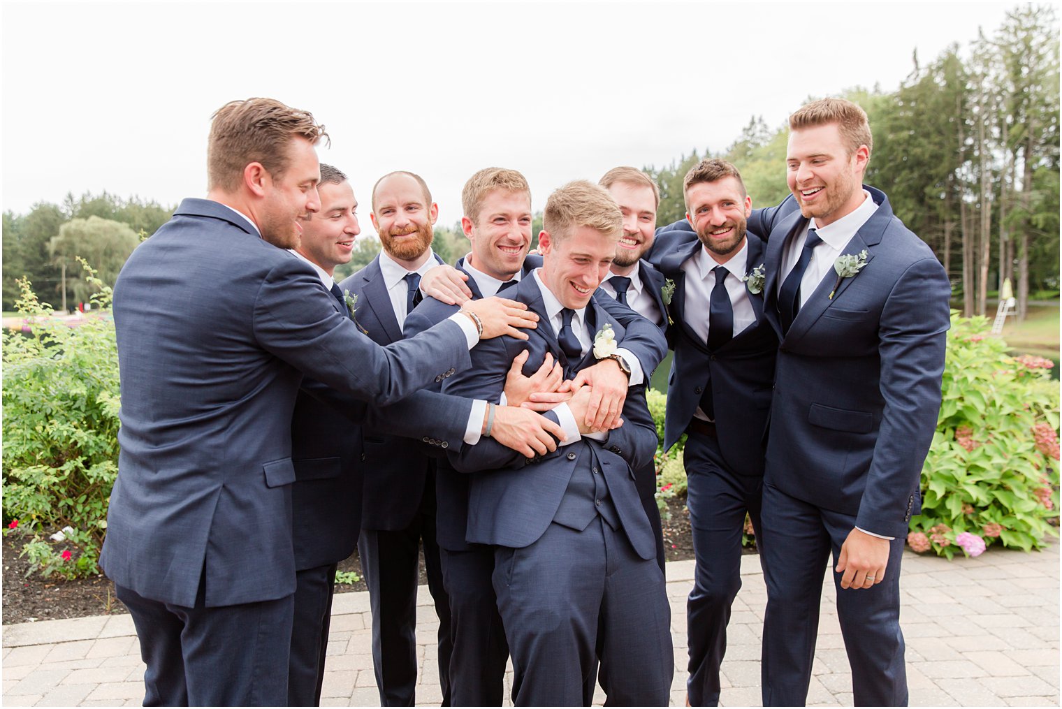 groomsmen hug groom