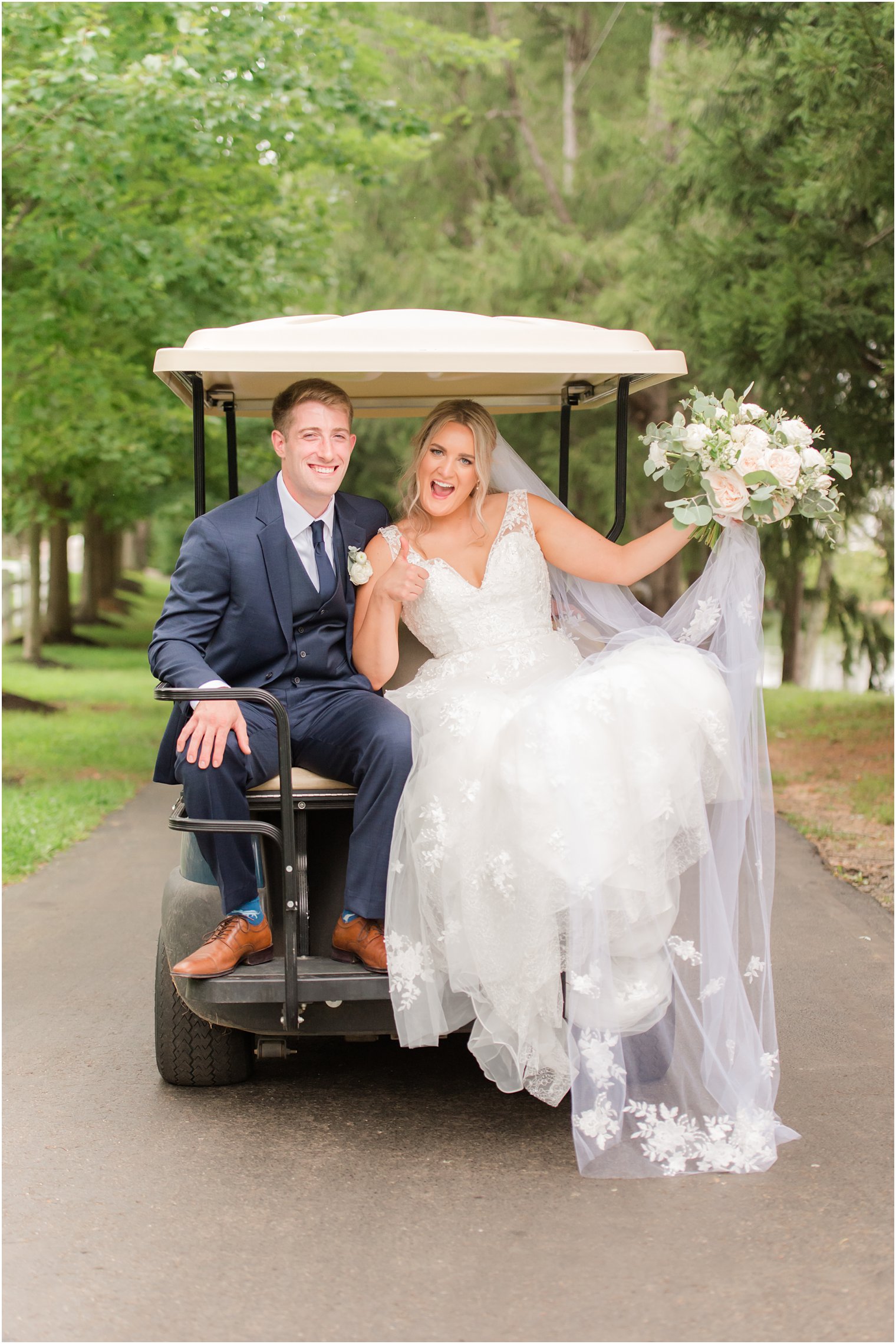 newlyweds ride on golf cart at Windows on the Water at Frogbridge