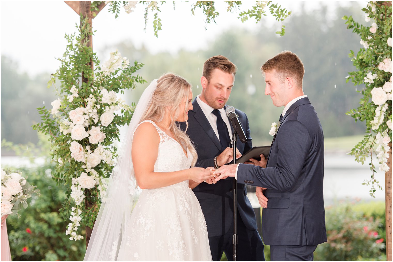 bride and groom exchange rings during NJ wedding ceremony 