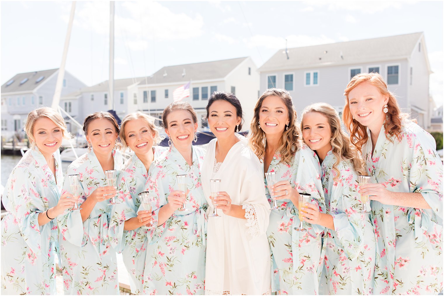 bride poses with bridesmaids in matching pale blue floral robes
