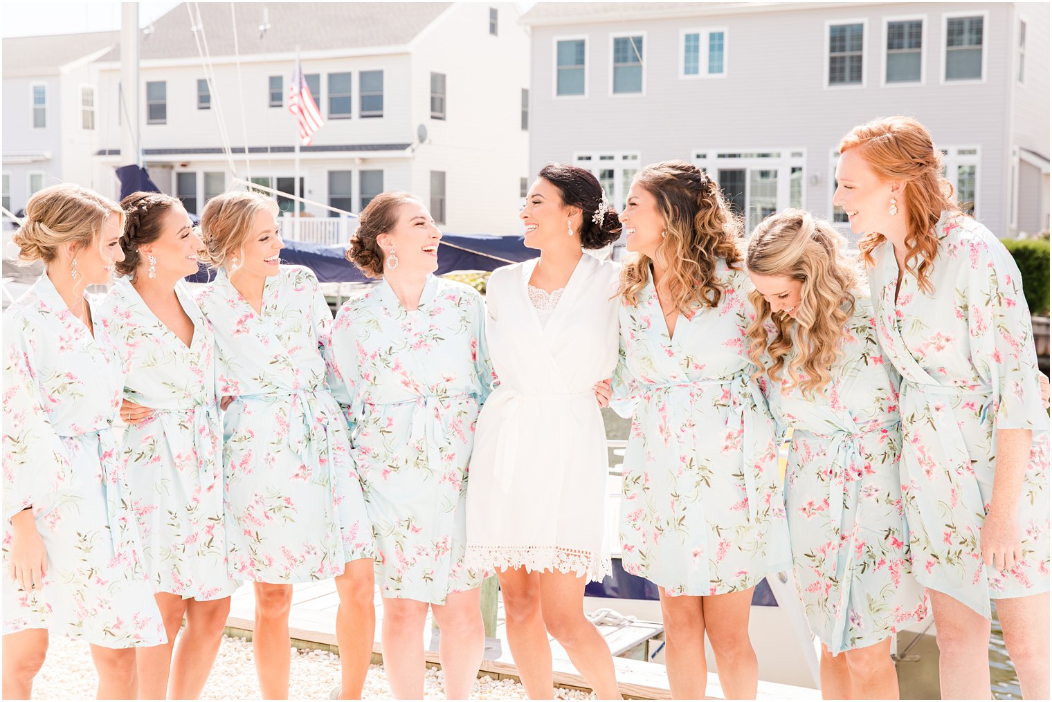 bride laughs with bridesmaids in blue robes