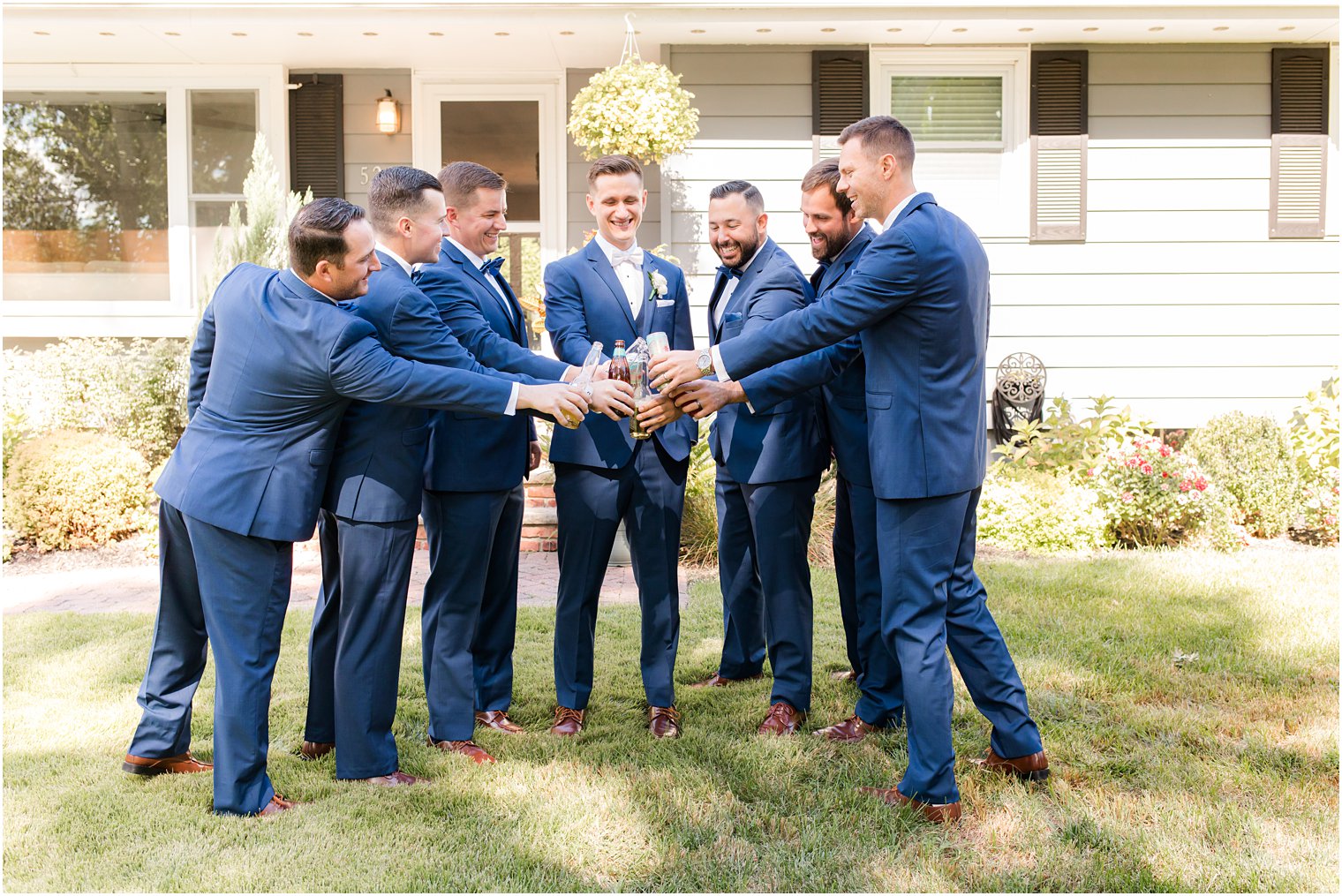groom and groomsmen toast in navy suits