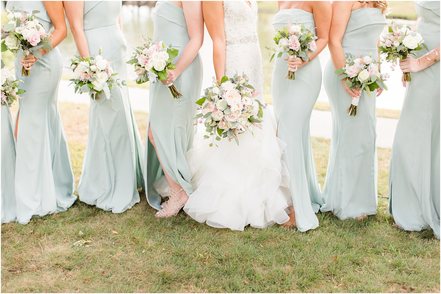 bride and bridesmaids hold pastel bouquets with sage green gowns