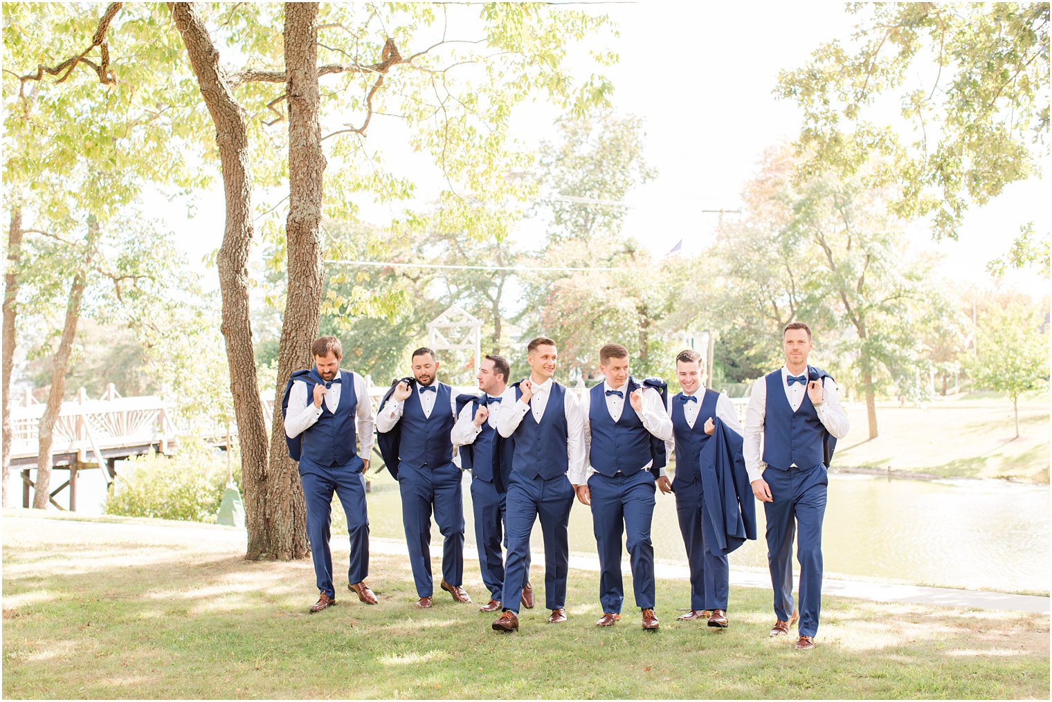 groom walks with groomsmen in navy suits