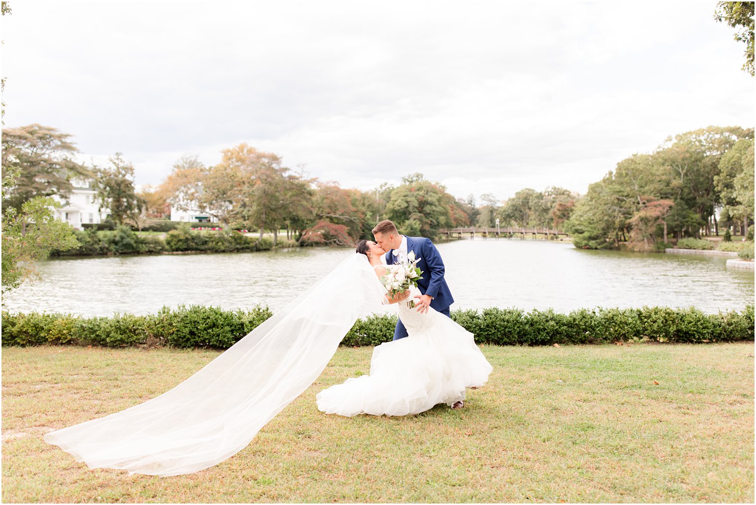 newlyweds kiss with bride's veil floating behind her