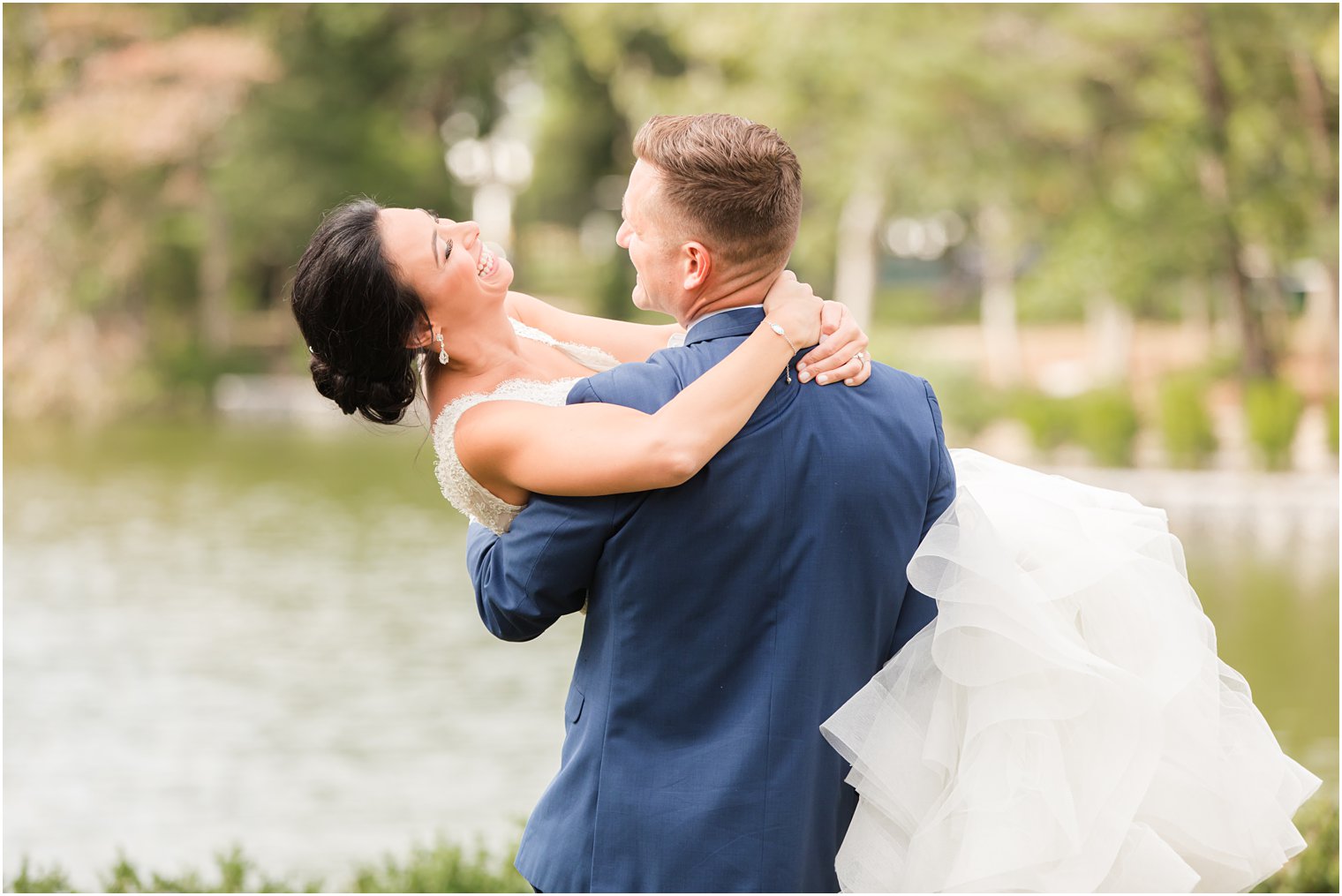 groom lifts bride during NJ wedding portraits