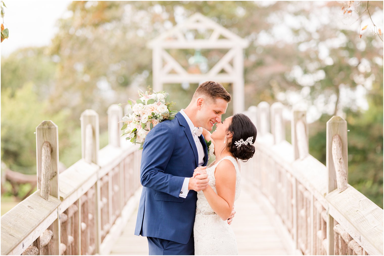 newlyweds laugh together on bridge near Clarks Landing