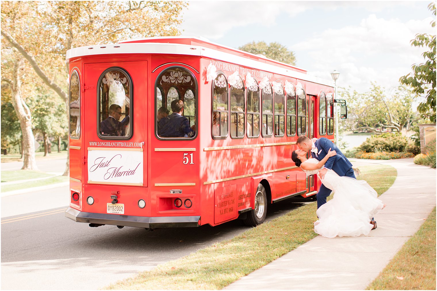 bride and groom kiss by red Long Branch Trolley