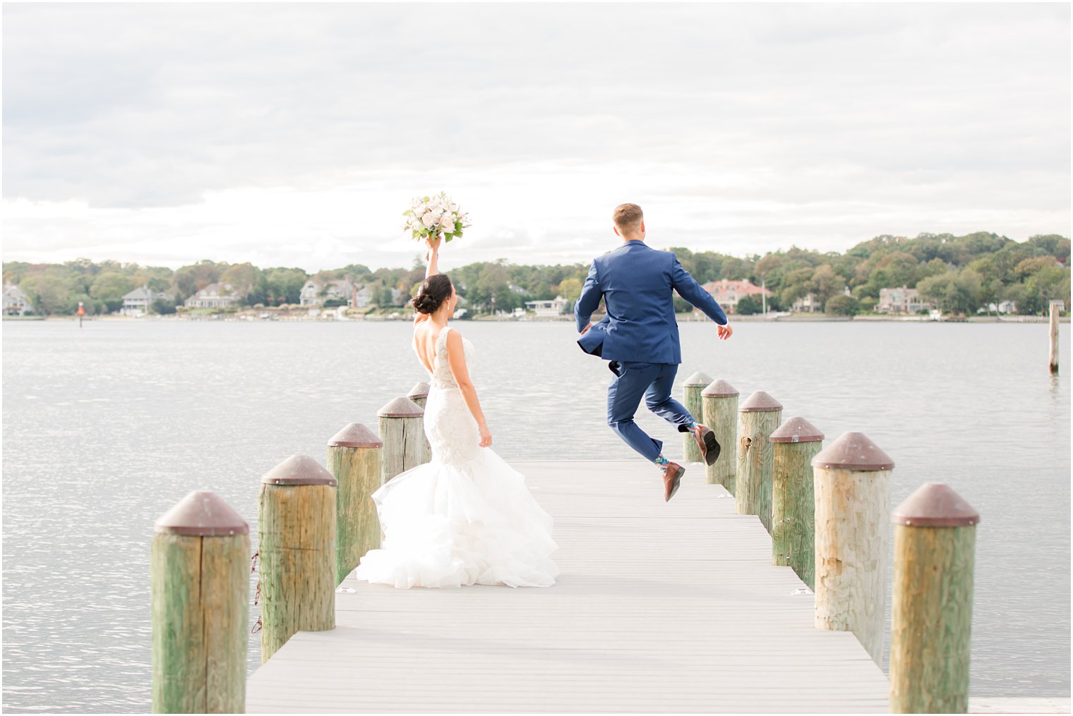 groom jumps with bride during wedding portraits in New Jersey