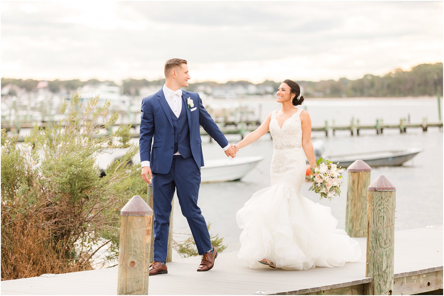 bride and groom hold hands walking on dock at Clarks Landing