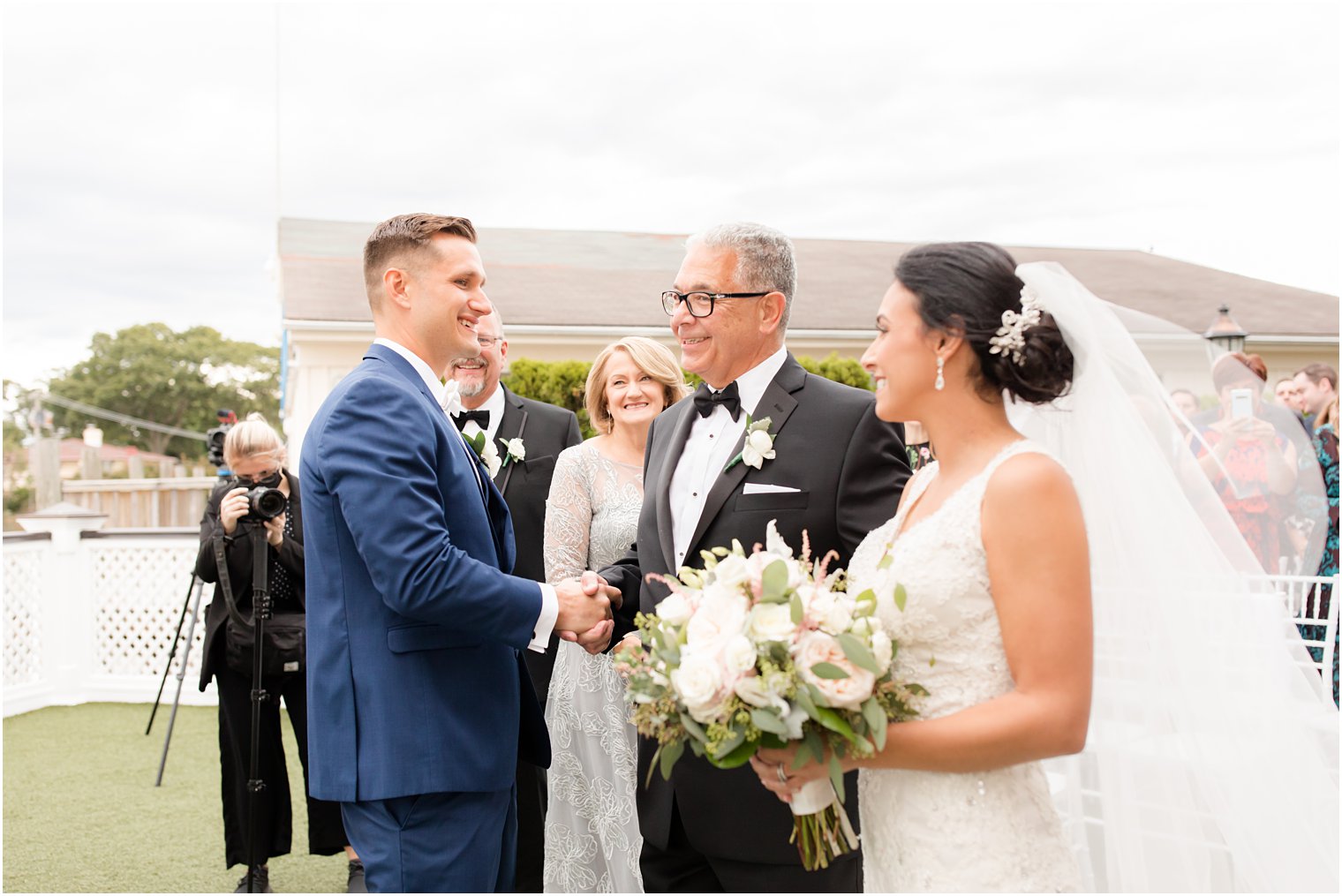 groom shakes bride's dad's hand during ceremony at Clarks Landing