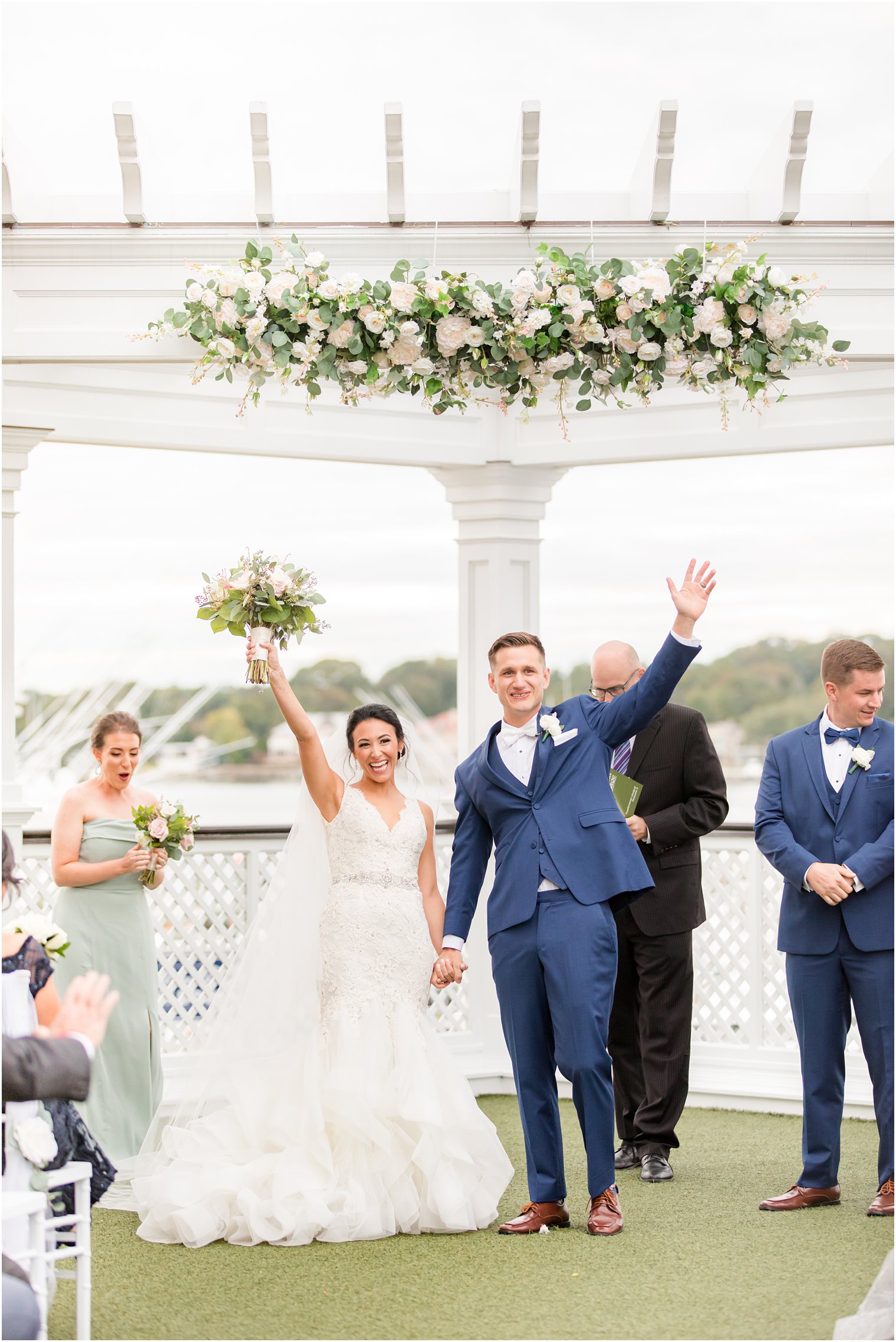 newlyweds cheer under arbor at Clarks Landing