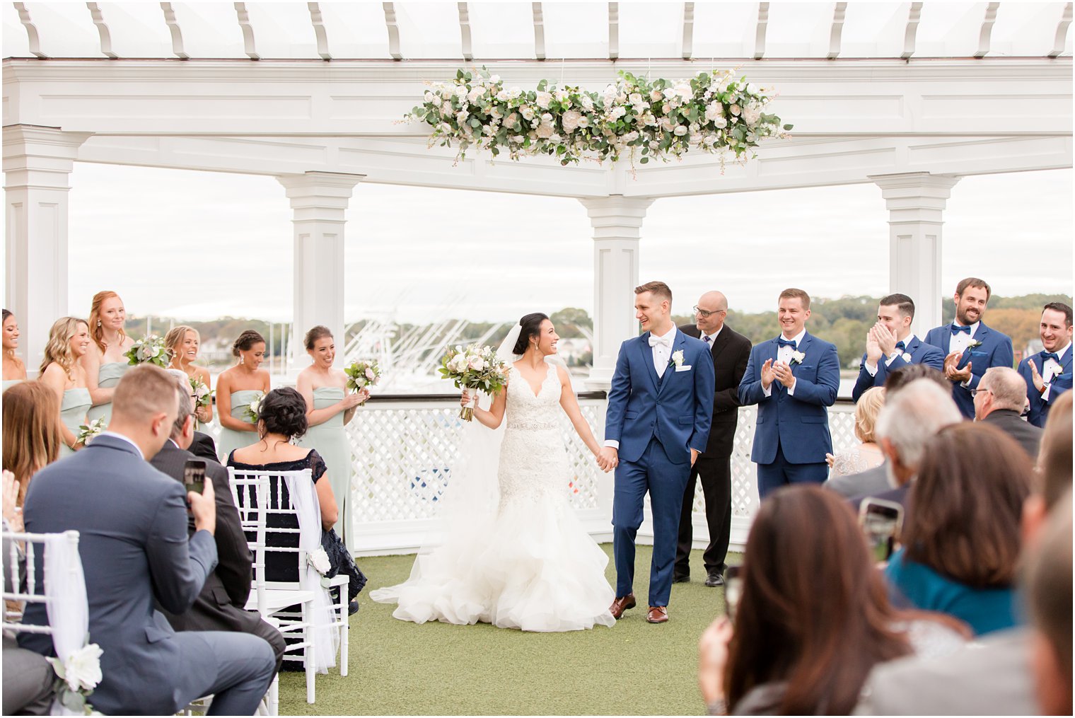 bride and groom hold hands leaving ceremony at Clarks Landing