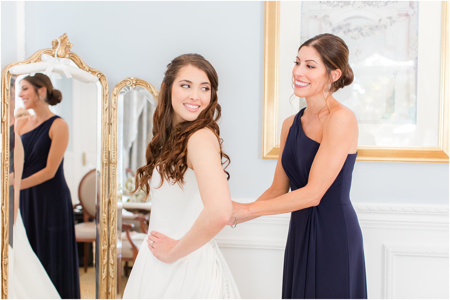 bridesmaid helps bride with gown before Farmingdale NJ wedding