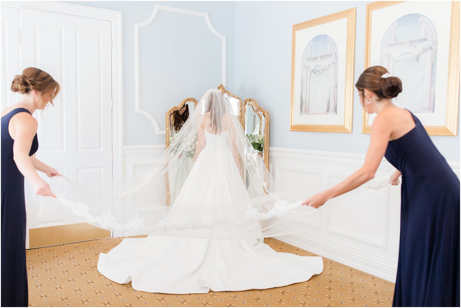 bridesmaids pull veil out for bride before Farmingdale NJ wedding