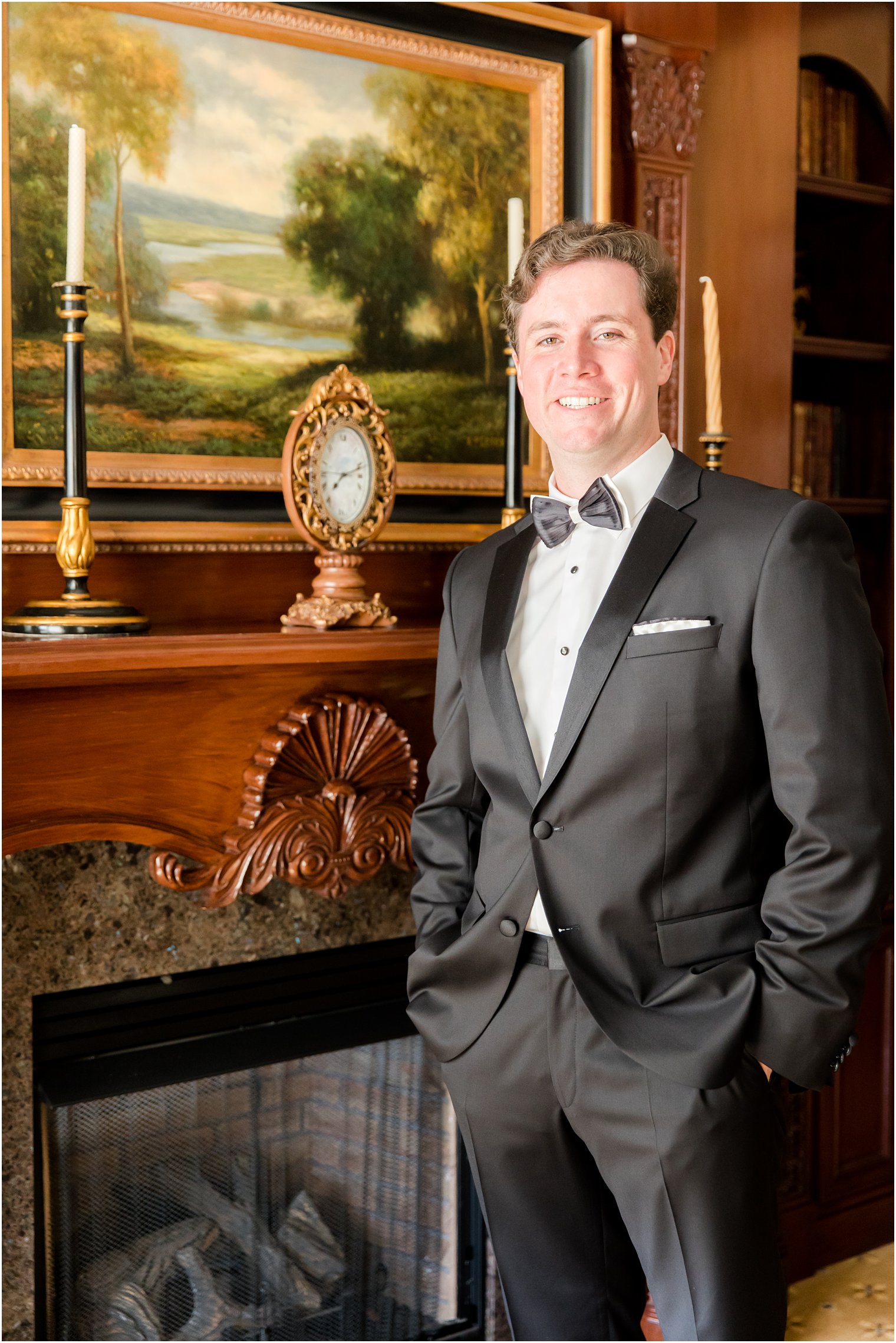 groom poses by wooden mantle at Eagle Oaks