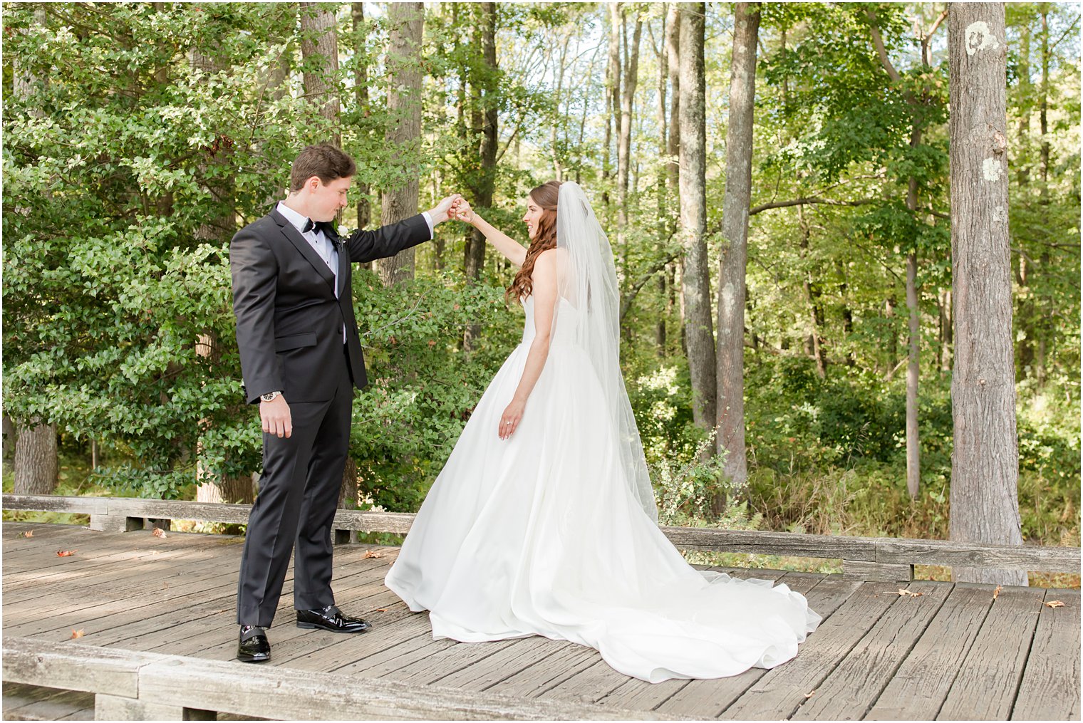 groom twirls bride during Eagle Oaks wedding day first look