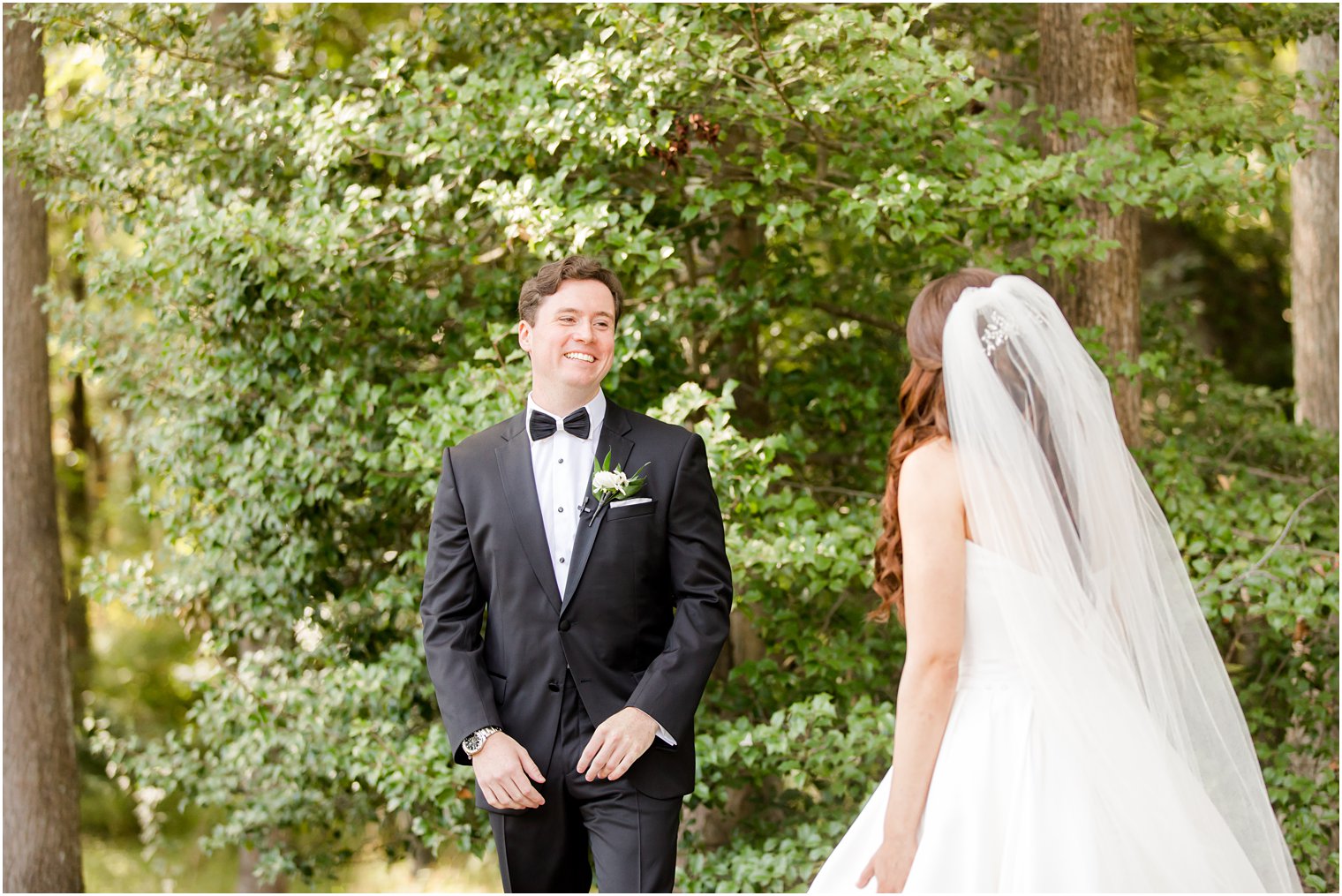 groom smiles at bride during first look at Eagle Oaks