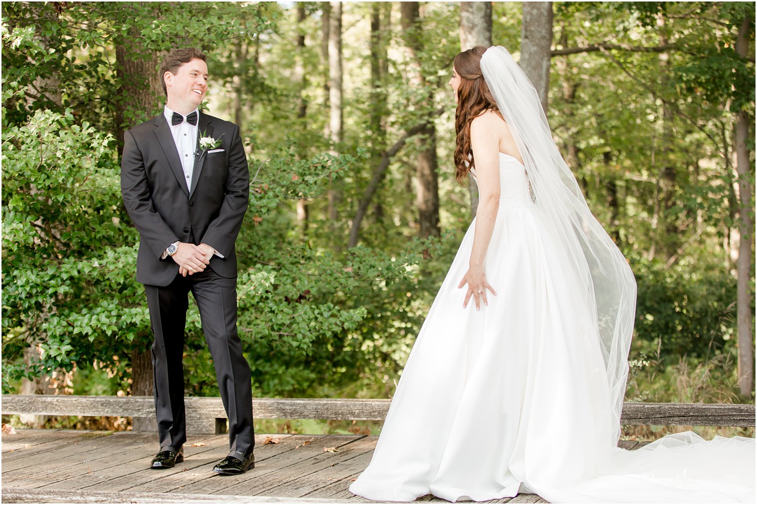 groom turns to look at bride during first look at Eagle Oaks 