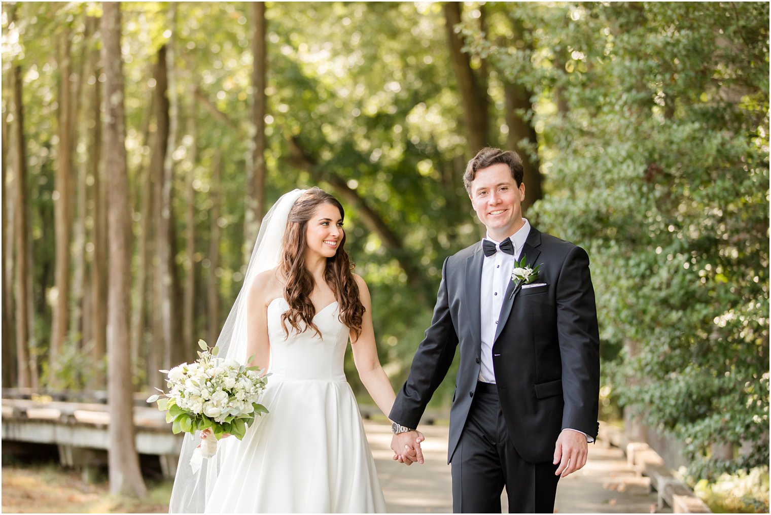 newlyweds walk through woods at Eagle Oaks Golf and Country Club