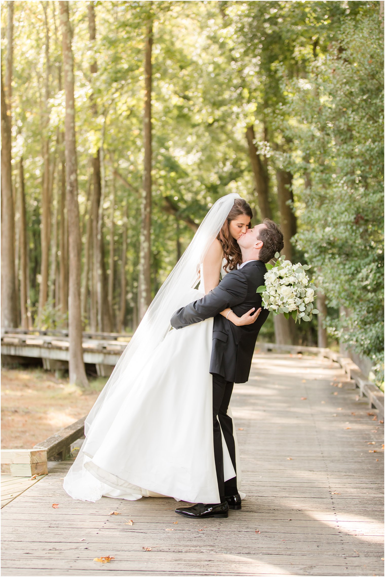 groom lifts bride during wedding portraits in New Jersey