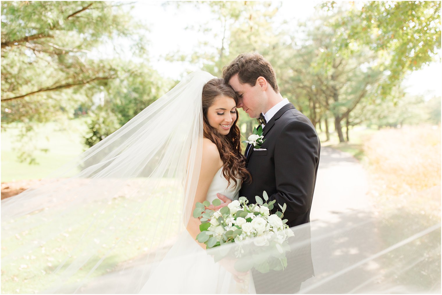 bride and groom hug with veil around them in New Jerey