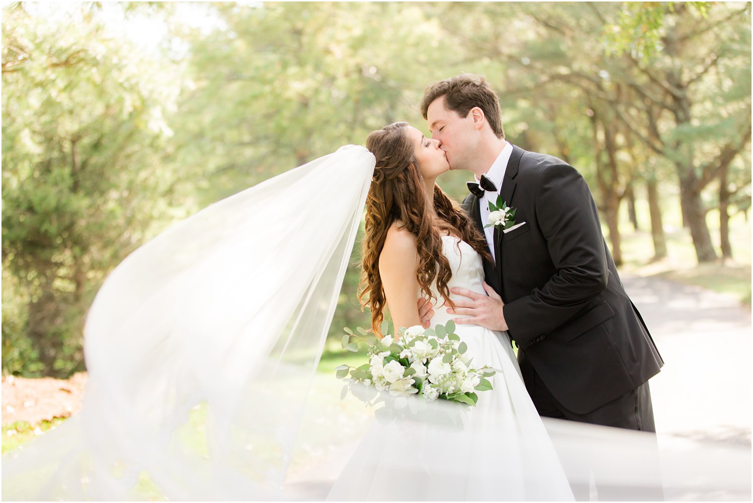 newlyweds kiss during Eagle Oaks Golf and Country Club wedding portraits