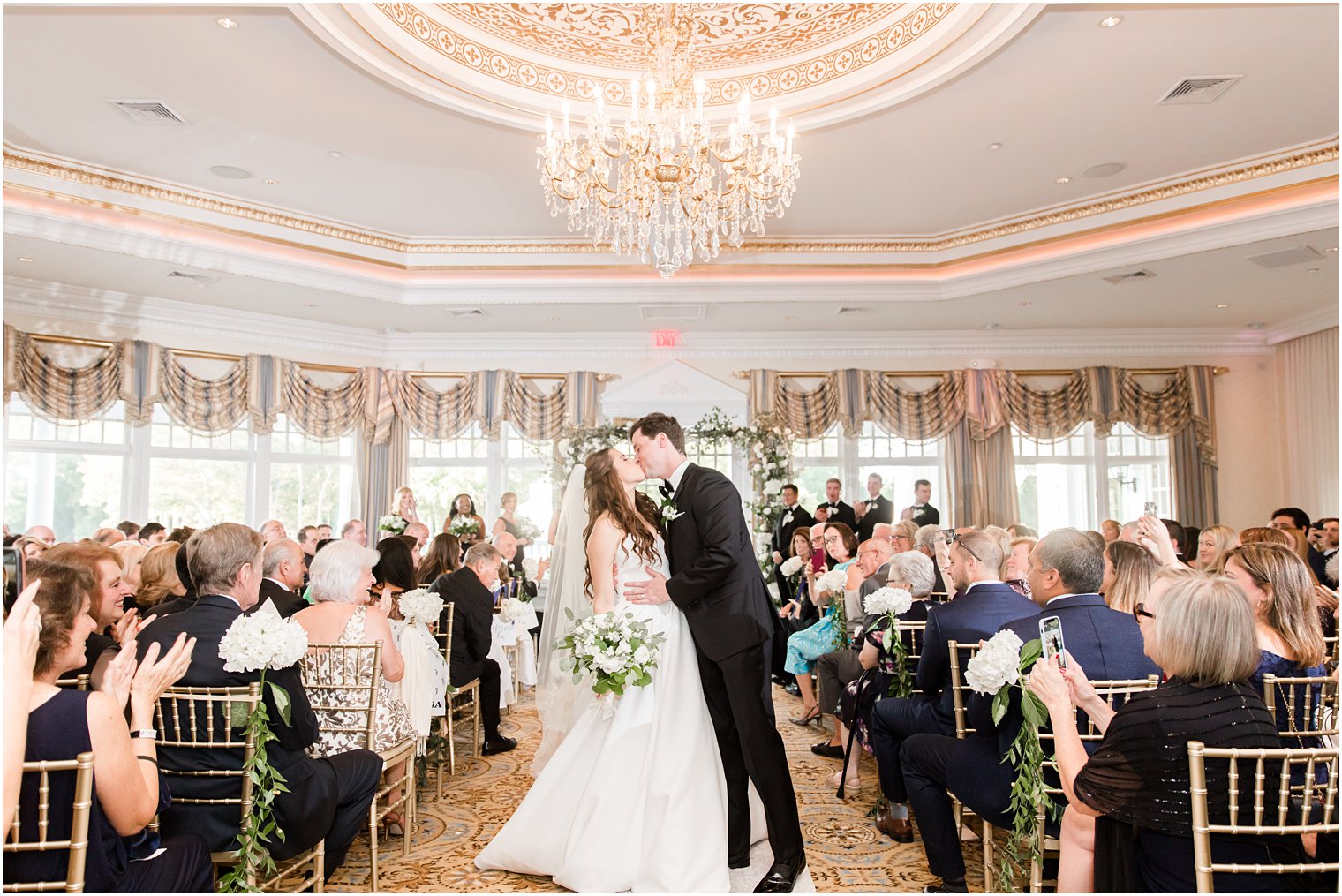 newlyweds kiss at end of the aisle at Eagle Oaks Golf and Country Club