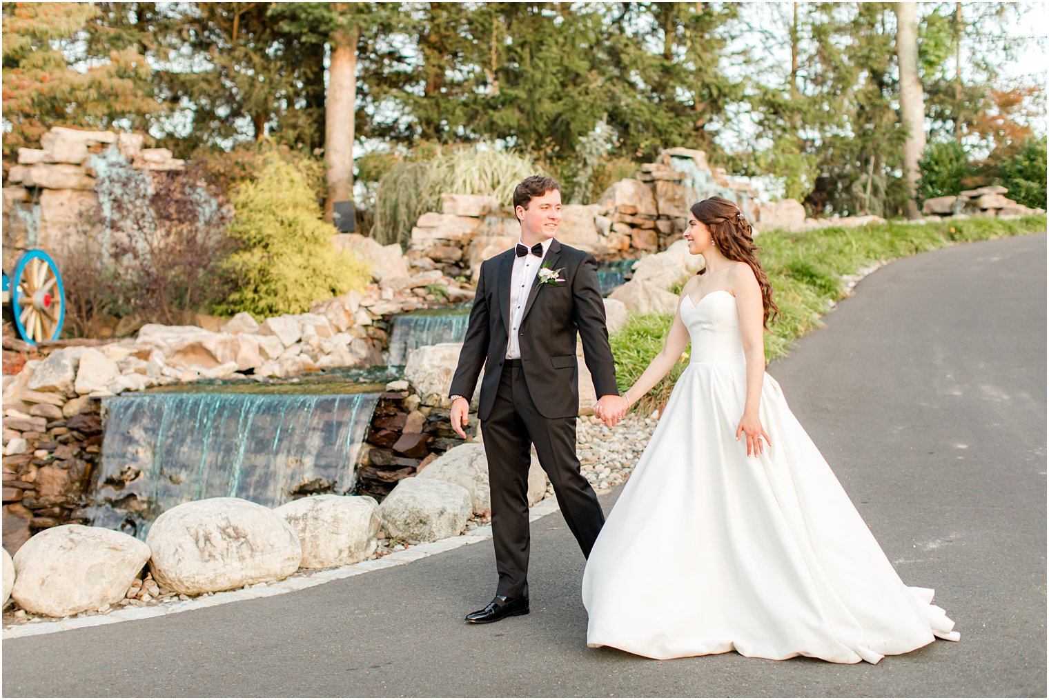 bride and groom walk down path in Farmingdale NJ