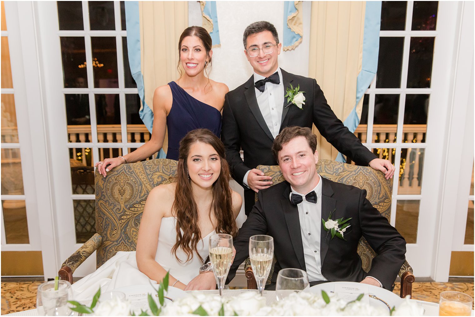 maid of honor and best man pose with newlyweds at Farmingdale NJ wedding reception