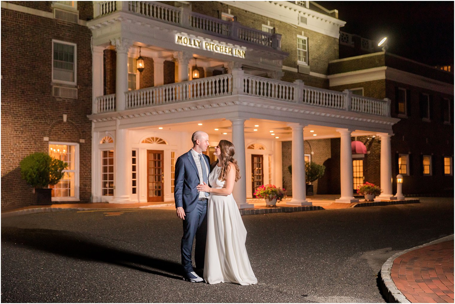 Bride and groom in front of Molly Pitcher Inn at night