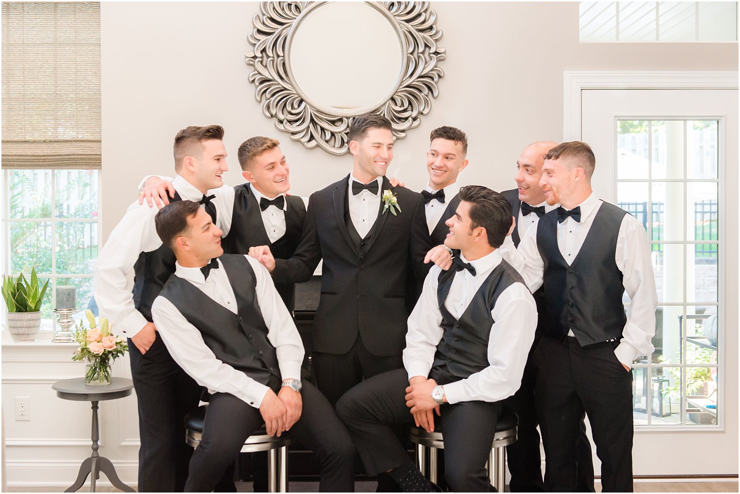 groomsmen look up at groom in NJ living room