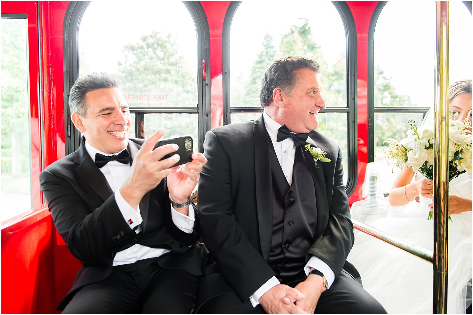dads laugh with bride and groom on trolley
