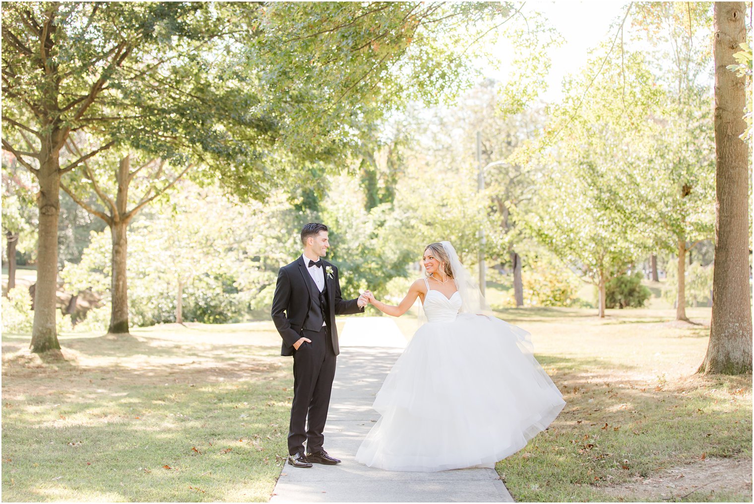 bride and groom walk along sidewalk in Spring Lake NJ