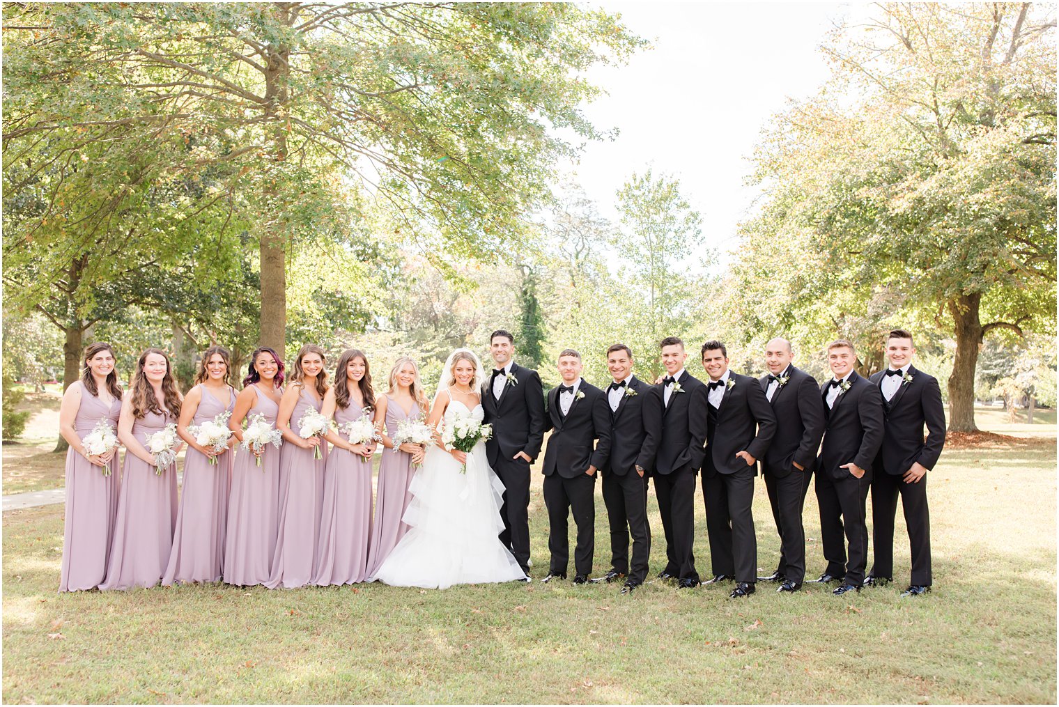 bride and groom pose with wedding party in Spring Lake NJ