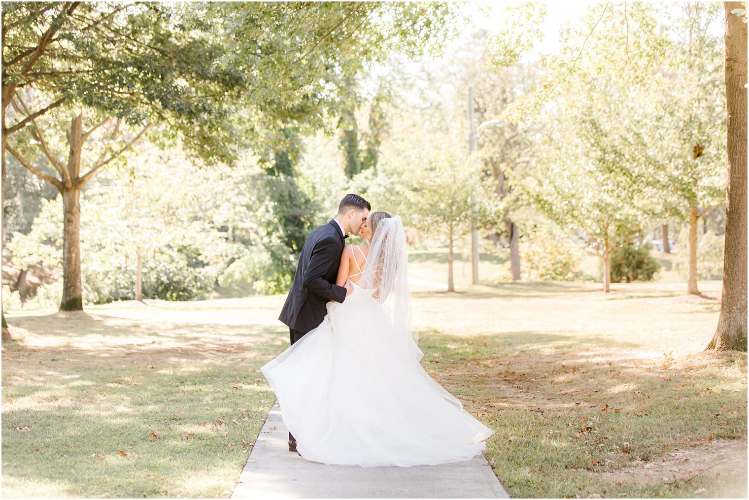 bride and groom kiss on sidewalk in Spring Lake NJ