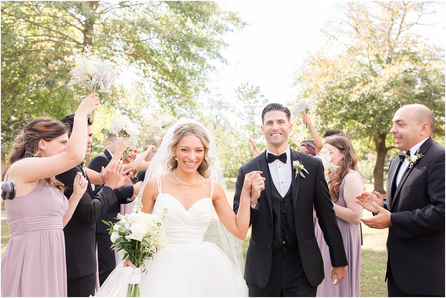 newlyweds walk through wedding party in Spring Lake NJ