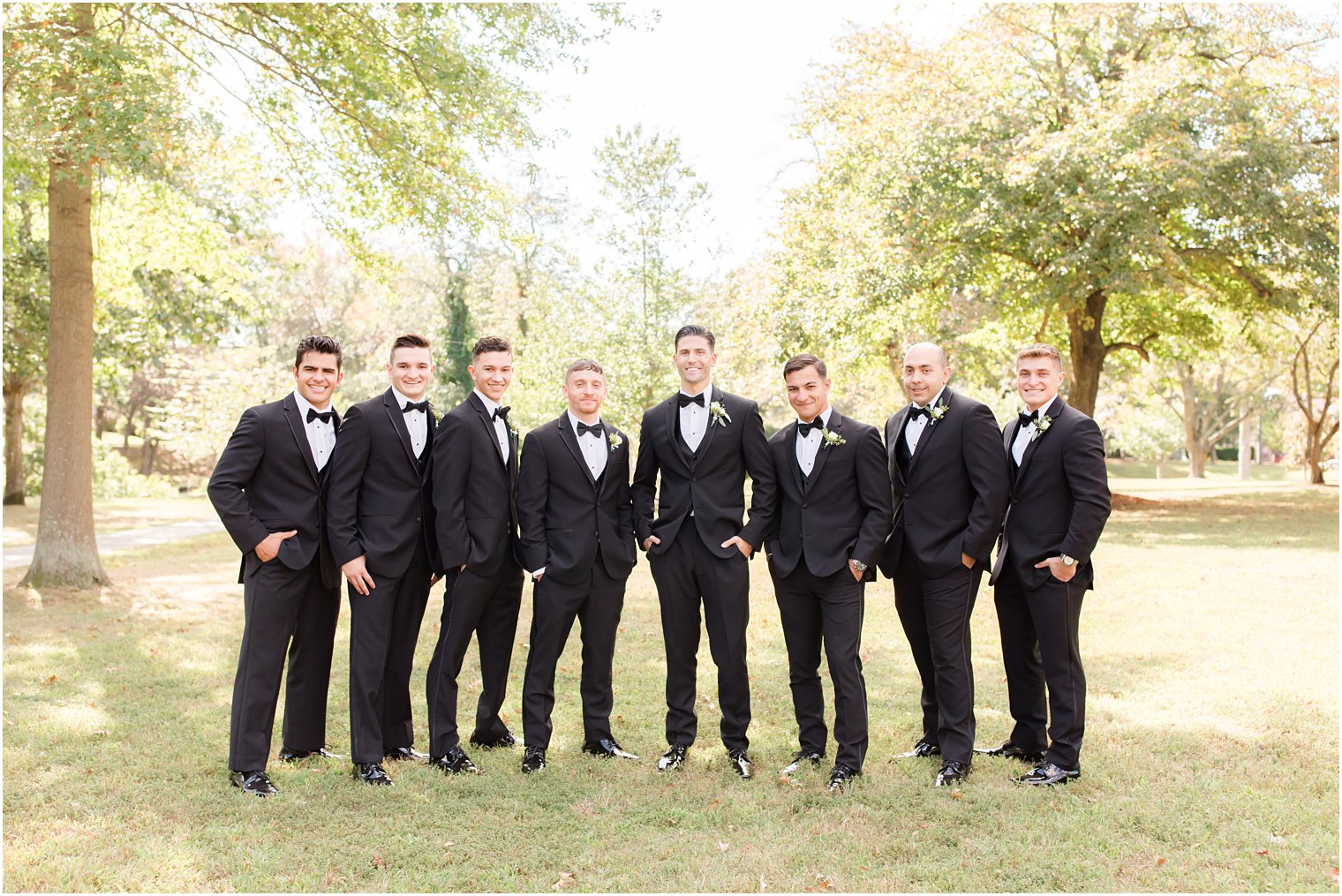 groom poses with groomsmen in classic suits