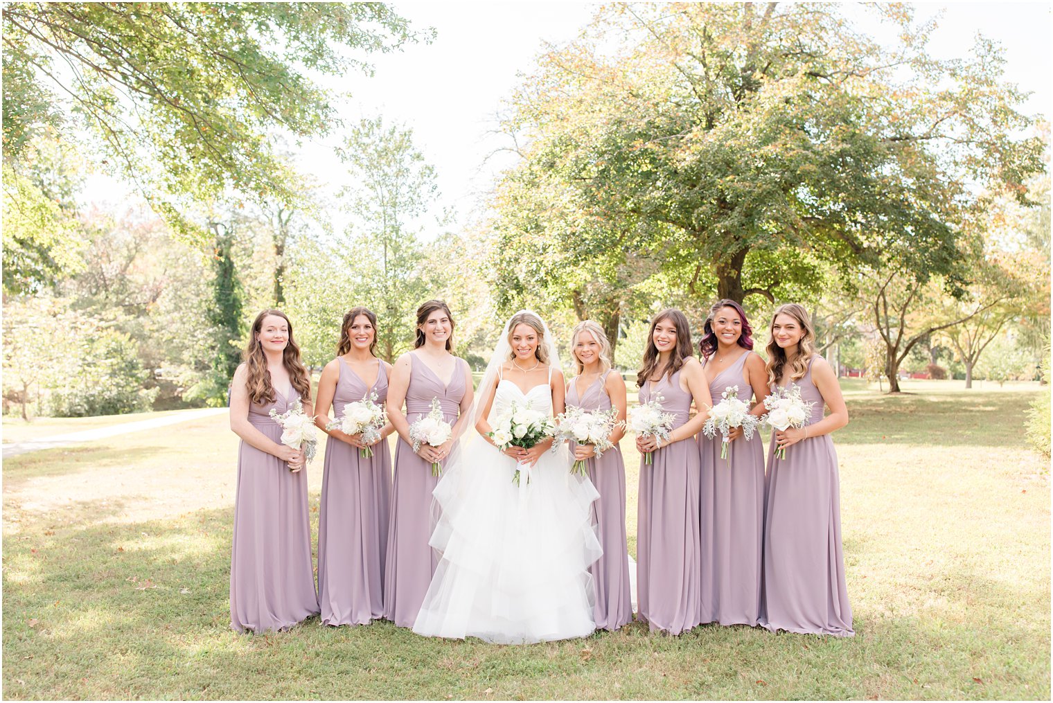 bride and bridesmaids in light purple pose together