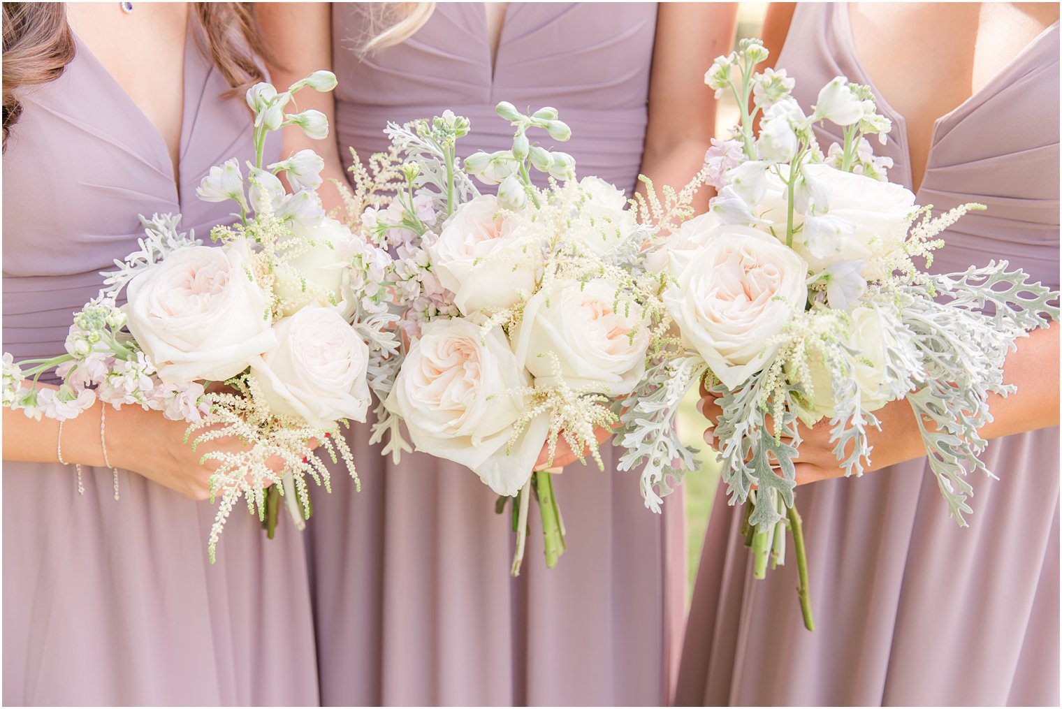 bridesmaids hold light pink bouquets