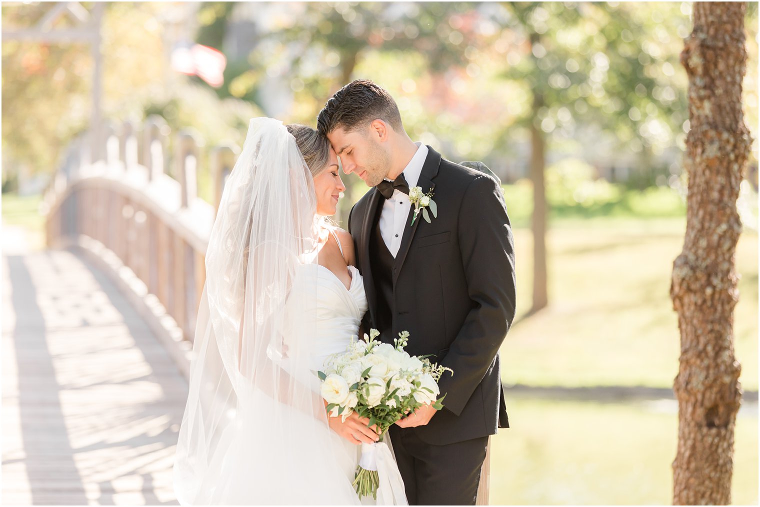 newlyweds pose on wooden bridge in New Jersey