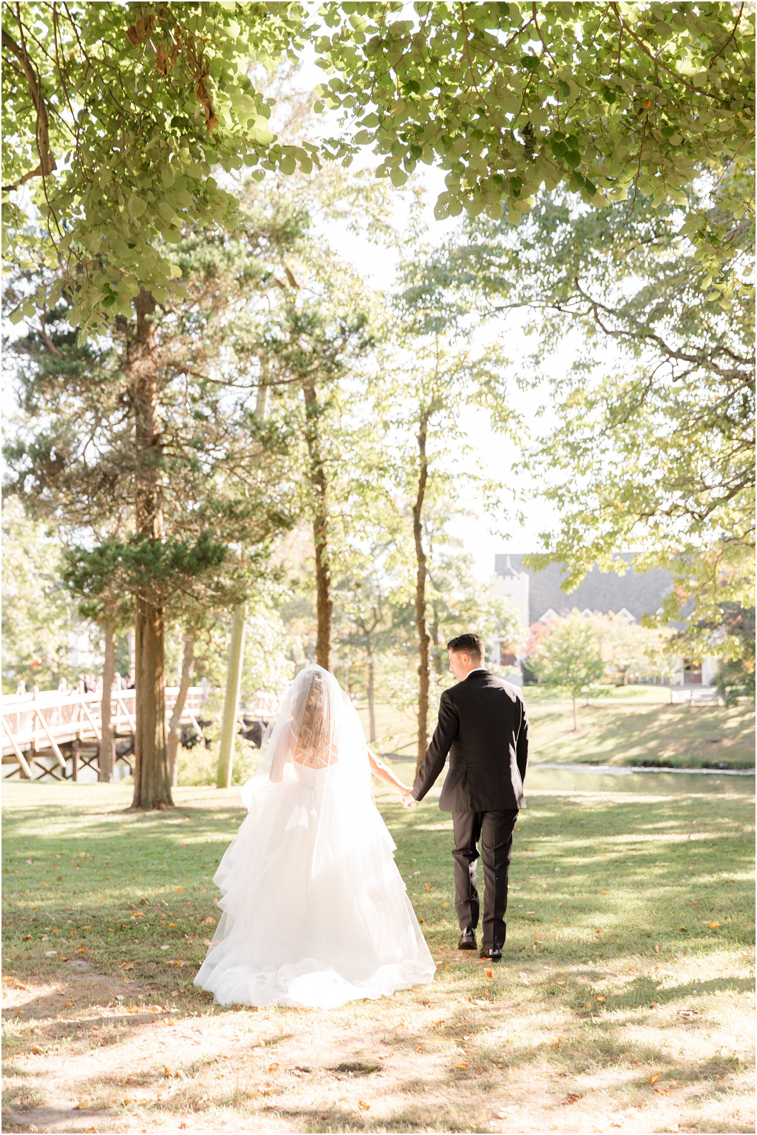 newlyweds walk through park in Spring Lake