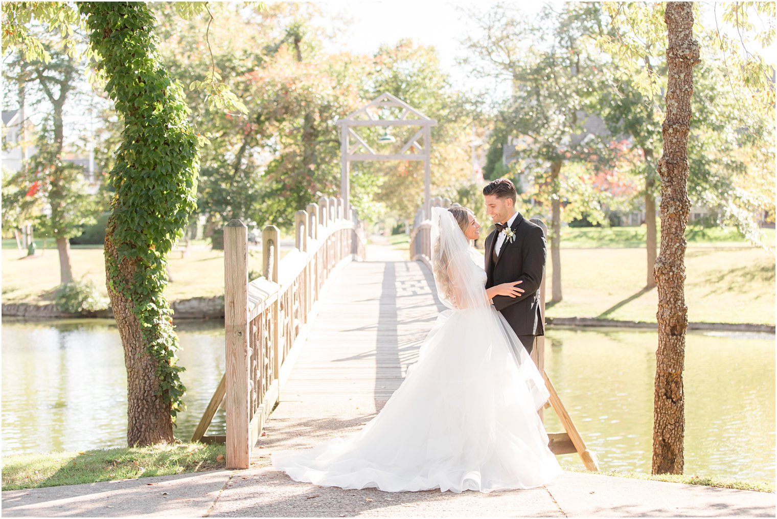 bride and groom pose on wooden bridge in Spring Lake NJ