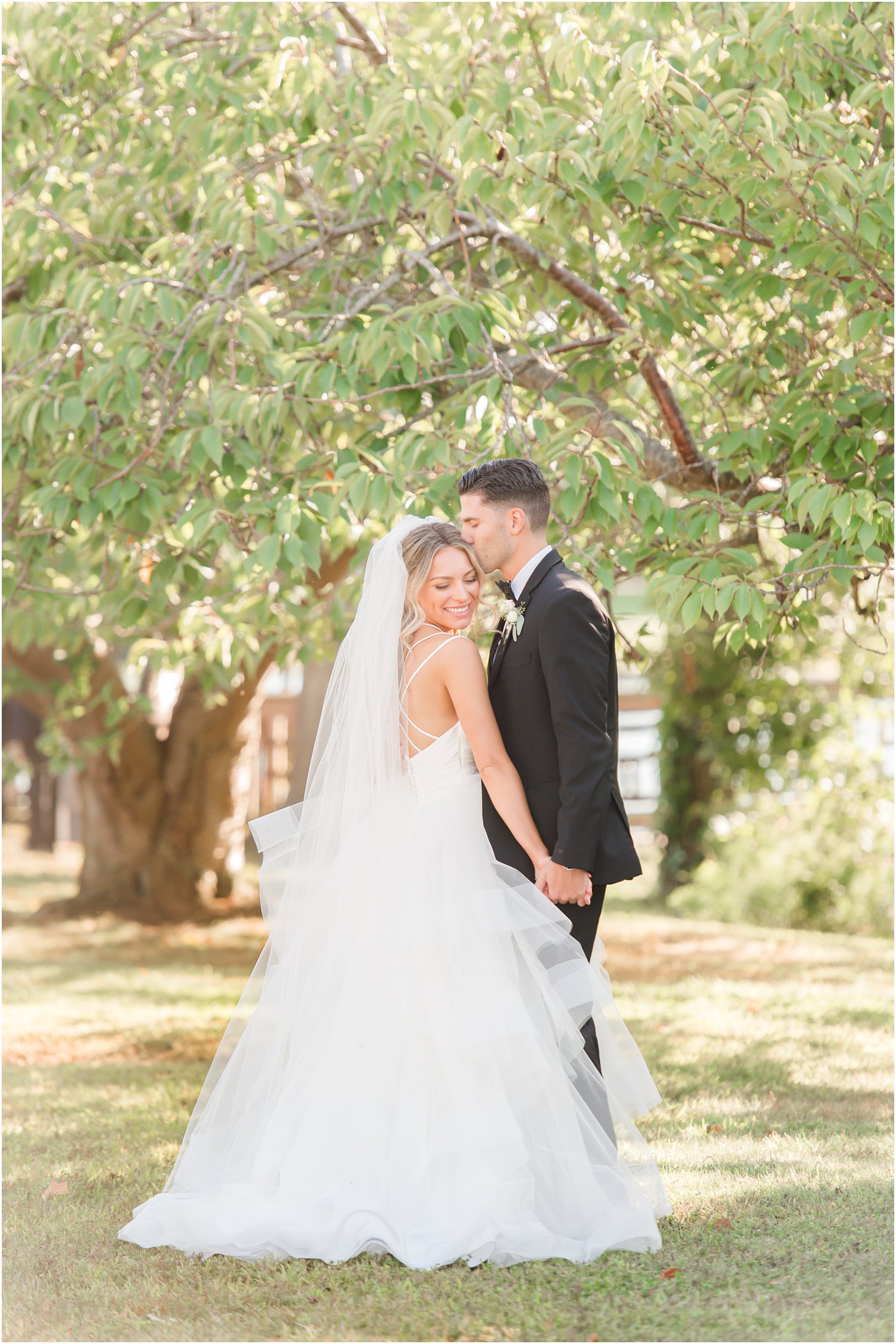 bride and groom kiss in Spring Lake NJ park