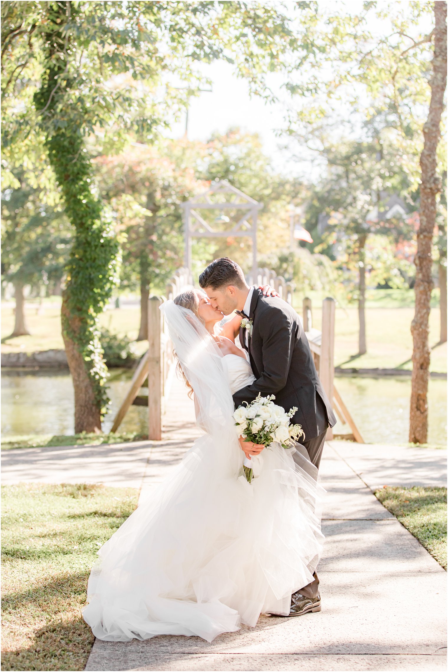 bride and groom kiss in Spring Lake NJ park