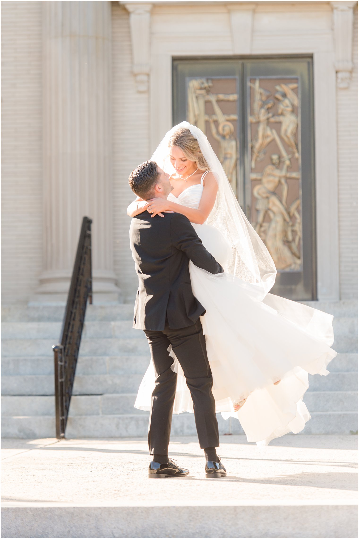 groom lifts bride during New Jersey wedding portraits