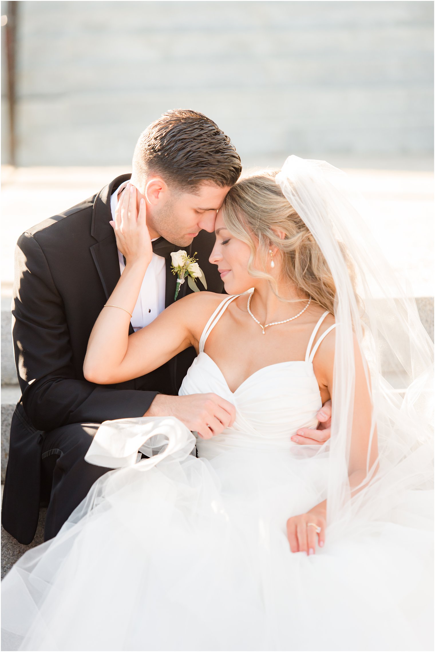 bride and groom sit together on steps at the Mill Lakeside Manor