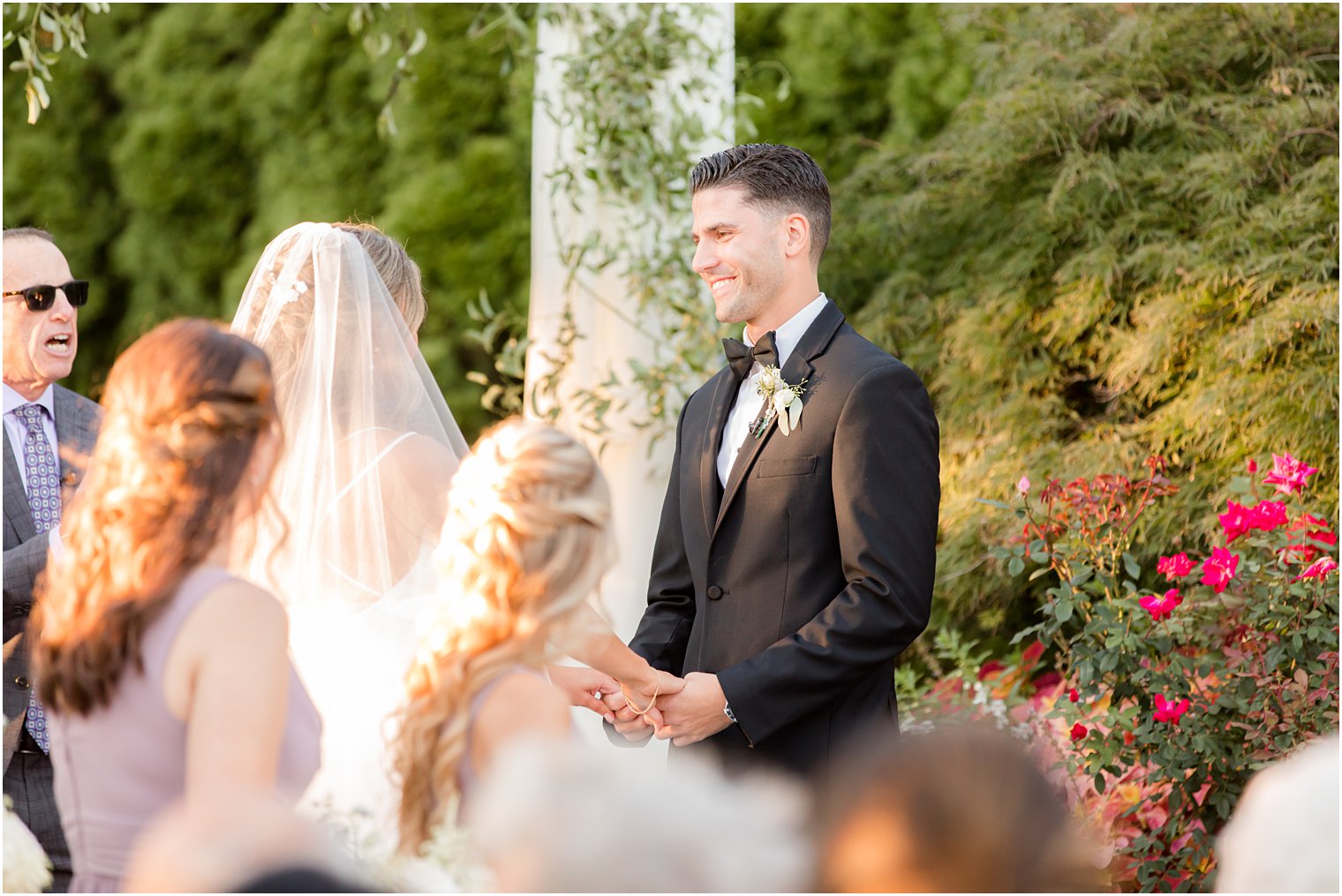 groom smiles at bride during wedding ceremony in Spring Lake NJ