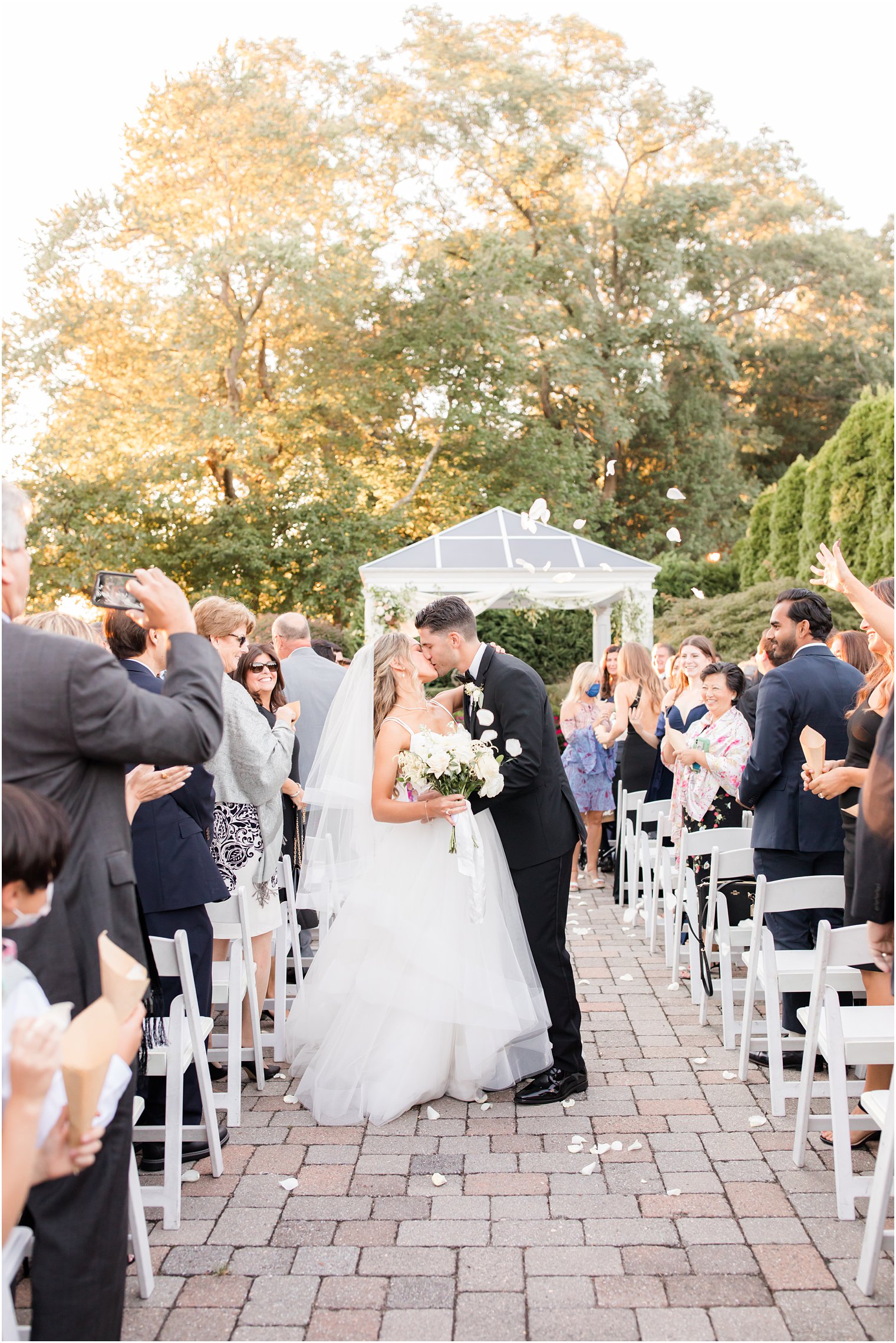 bride and groom kiss walking up the aisle at the Mill Lakeside Manor